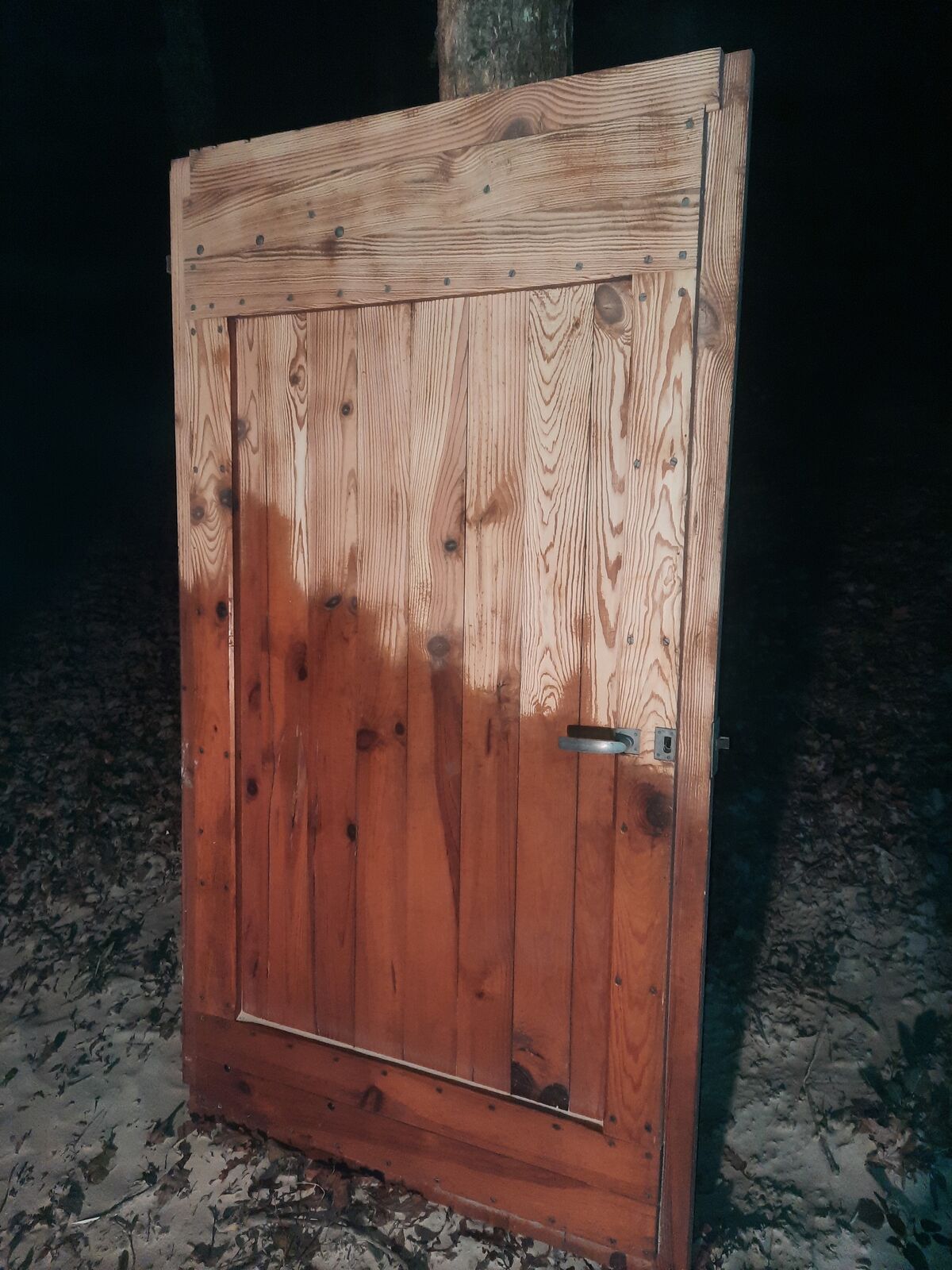 Porte en bois à moitié décapée par sablage, la partie traitée retrouve un bois clair d'aspect naturel